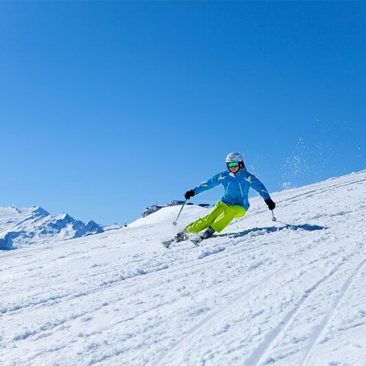 Skiers on the Schmittenhöhe with Kitzsteinhorn in the background